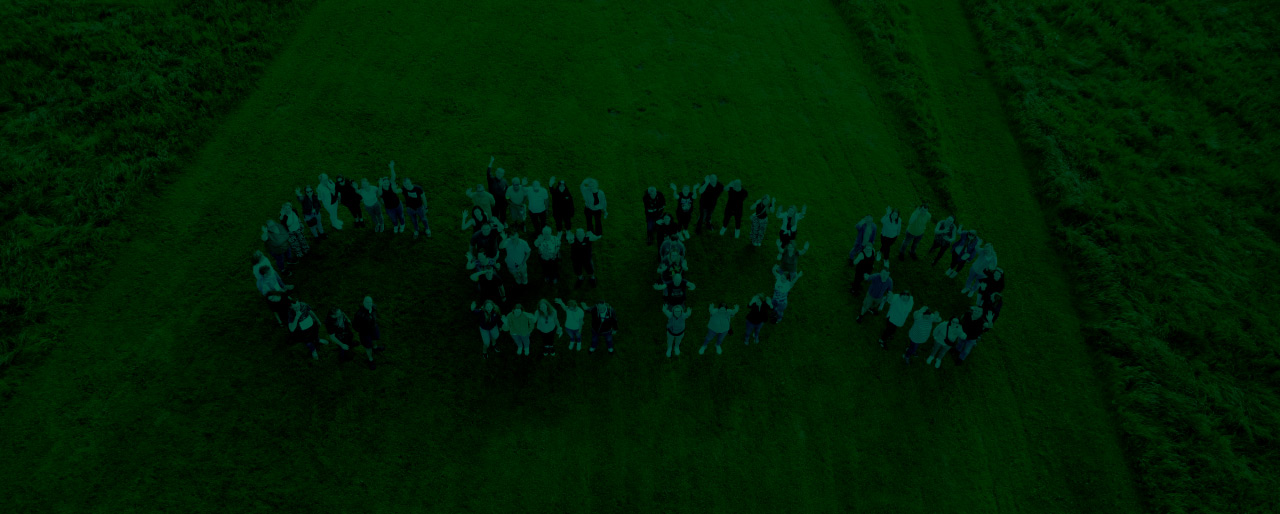 People forming a circle in a green field